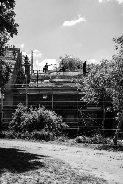 Wandergesellen bauen unter den Dachstuhl des Bullenstalls.